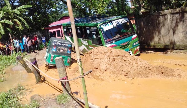 বিশ্বনাথের সড়কে বড় বড় গর্ত আটকে পড়ে বাস : জনদূর্ভোগ চরমে